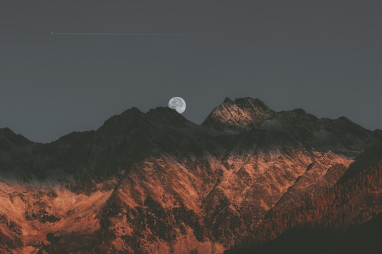 moon setting over mountains